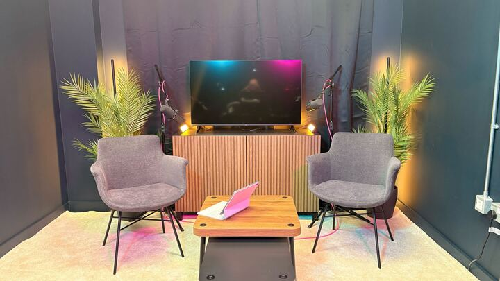 Professional podcast studio setup with modern seating and ambient lighting